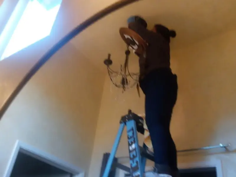 Electrician installing a chandelier in a Ellsworth residence